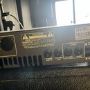 Zadní strana šedého rackového zesilovače značky Ampeg. Na přístroji jsou vstupy a výstupy s popisky POWER AMP IN, PREAMP OUT, RETURN, SEND, POST PRE…