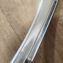 Detail chromovaného kovového rámu hudebního nástroje. Na povrchu je viditelný malý, svisle orientovaný nápis "MADE IN ITALY". Povrch je lesklý s vidi…