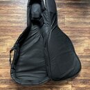 Černý poloměký pouzdro (gig bag) na kytaru, zobrazené otevřené z pohledu zevnitř. Vnitřní prostor je vyložen černým textilem a v horní části je vidit…