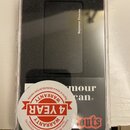 V průhledném plastovém obalu je umístěn černý kytarový snímač typu humbucker s krytem, na kterém je nápis Seymour Duncan. Pod snímačem je vidět papír…