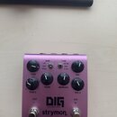 Fialový efekt pedál s nápisy DIG, dual digital delay a strymon. Na horní části jsou čtyři otočné knoflíky s popisky TIME / TIME 2, TONE, REPEATS a MI…