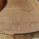 Fotografie zachycuje vnitřek otevřeného tvrdého pouzdra na hudební nástroj. Interiér je vyložen světle hnědým materiálem, který vykazuje známky opotř…