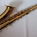 Zlatý saxofon s kovovým povrchem. Nástroj je zobrazen v celku na světlém podkladu. Na viditelných částech nástroje nejsou žádné čitelné značky ani ná…
