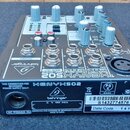 Zadávací panel mixážního pultu značky behringer s modelem XENYX 502. Jsou vidět vstupy LINE IN, MAIN OUT a výstup PHONES, spolu s několika ovládacími…