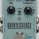 Světle modrý efekt pedál s nápisy QUINTESSENCE HARMONIZER a tc electronic. Na horní části jsou tři černé otočné ovladače s popisky KEY, SCALE a HARMO…