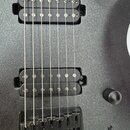 Detail elektrické kytary s černým třpytivým povrchem. Nástroj má dva humbuckery, přičemž na spodním je čitelný nápis Seymour Duncan. V dolní části je…