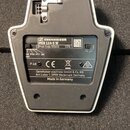 Zadní strana bílého elektronického zařízení s černým plastovým panelem. Na štítku je uveden nápis SENNHEISER, model MEB 114-S W a Prod. Code: 505616…
