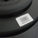Detail černého reproduktoru. Na povrchu je bílá nálepka s čárovým kódem a nápisem LEMON/2412. V horní části je do materiálu vlisovaný nápis THIS SIDE…