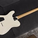 Zadní strana bílé elektrické kytary s jasným dřevěným hřednicí a černými ladičkami. Na hlavě je viditelné logo „Suhr“ a nápisy „S2 STRATOCASTER“ a „M…