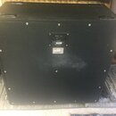 Zadní strana černé kytarové reprobedny s dvěma madly na horní části. Uprostřed je umístěn ovládací panel s nápisem 1960BV 4x12 a štítkem, na kterém j…