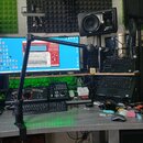 Fotografie zachycuje domácí studio s pracovním stolem, na kterém je monitor s otevřeným softwarem pro tvorbu hudby, notebook a několik kontrolérů. V…