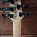 Zadní strana hlavy basové kytary zC světlého dřeva se čtyřmi černými ladicími kolíky. Na dřevě je vyryto CE RoHS, S/N: 190602047, made in Korea srl a…