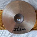 Kruhové činely z bronzu s viditelným kováním povrchu. Na spodní straně je černý nápis Zildjian a malá bílá nálepka s čárovým kódem. Povrch vykazuje m…