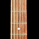 Fotografie zachycuje hmatník a hlavu elektrické kytary s černým lakem. Na hlavě jsou bílá loga „Gibson“ a „Les Paul JUNIOR“. Hmatník je vyroben z tma…