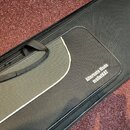 Černý obal na hudební nástroj s šedým pruhem a rukojetí. Na povrchu je bílý nápis Alternate Mode malletKAT. Povrch vykazuje mírné znečištění a opotře…