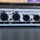 Bílý pasivní monitorovací kontroler s nápisem Palmer PMC1 Musicon PASSIVE MONITOR CONTROLLER a označením CE. Zařízení má dva vstupy (INPUT) a dva výs…