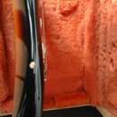 Detailní pohled na hranu hmatníku a krku kytary s tmavě hnědým a oranžovým povrchem. Na černé hraně krku je vidět světlý odřap nebo stěr povrchového…