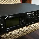 Černý rackový procesor s nápisy FRACTAL AUDIO SYSTEMS a Axe-Fx II PREAMP FX PROCESSOR. Na předním panelu je umístěn displej, ovládací knoflík a řada…