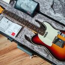 Elektrická kytara typu Telecaster s barevným přechodem korálovo-černým (sunburst) a bílým pickguardem. Na hlavě hmatníku je viditelné logo Fender. V…