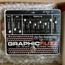 Kytarový efekt pedál v bílém rámu s černým ovládacím panelem. Na spodní části je nápis GRAPHIC FUZZ s přívlastkem with variable envelope response a l…
