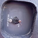 Fotografie zachycuje vpadlou část černého plastového nebo lakovaného povrchu s konektorem. Vedle konektoru je bílý nápis VSTUP 50 W/15Ω a u samotného…