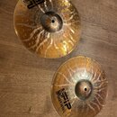 Dvě kovové činely zlaté barvy s povrchovými otvory a světlými ornamenty. Na obou je černý nápis „FIP“ doprovázený logem tygra a textem „TIGER SERIES“…