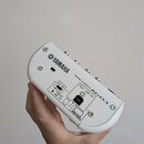 Bílá míchací konzole s nápisy YAMAHA a MIXING CONSOLE AG03. Na zadní straně jsou konektory USB 2.0, 5V DC a TABLET USE DC. Zařízení vykazuje mírné zn…