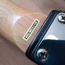 Detail krku a zadní strany hlavy kytary z dřeva s černým lakovaným povrchem hlavy. Na krku je nalepený bílý štítek s nápisem MODEL FOCUS VT-211S/BK.…