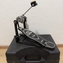 Černý basový pedál s kovovými prvky, umístěný na černém tvrdém kufru. Na pedálu je bílý nápis IRON COBRA a dále menší text, který je nečitelný, a náp…