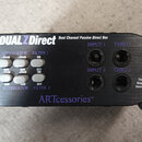 Černá pasivní DI box s kovovým vrchem a nápisem DUALZDirect Dual Channel Passive Direct Box. Zařízení obsahuje přepínače ATTENUATOR a FILTER 1 i 2 s…