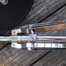Kromý chromovaný klamper s černými gumovými rukojtěmi. Na kovové části je viditelný nápis LOCK. Povrch je lesklý, s mírnými odrazy okolí.