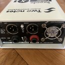 Bílé kovové zařízení s černým zadním panelem. Na horní straně jsou nápisy Two notes AUDIO ENGINEERING, Torpedo Captor X a REACTIVE LOAD BOX. Zadní pa…