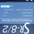 Detail technického štítku na černém reproduktoru. Je na něm uveden nápis Professional Music Monitor a model Sr-8/2. Štítek obsahuje údaje: IMPEDANCE…