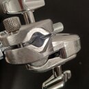 Detailní záběr na kovovou stěhku v chromovaném povrchu. Předmět je vybaven dvěma utahovacími šrouby s knoflíky a dvěma zdrsněnými vřeteny. Povrch vyk…