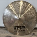Zlatý činely typu crash s výrazným kmitavým povrchem a kmitočtovými rýhami. Na spodní části je černý nápis UFIP Rough Series EARCREATED CYMBALS. V ho…
