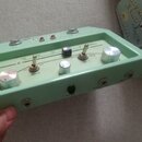 Světle zelený efektový pedál s kovovými ovládacími knoflíky a přepínači. Na horní části je nápis Danelectro a červené kontrolky. Na předním panelu js…