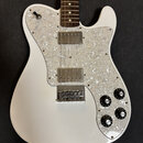 Bílá elektrická kytara s perleťovým pickguardem. Nástroj má dva humbuckery a čtyři ovládací knoflíky s číslicemi 1 až 10. Na kytáře nejsou viditelné…