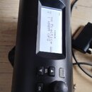Černý elektronický perkusní modul značky Roland s nápisem Roland TD-4 PERCUSSION MODULE. Zařízení má LCD displej, na kterém je viditelný text COACH P…