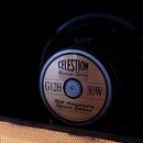 Fotografie zachycuje reproduktor v černém rámu, umístěný uvnitř skříně. Na středovém štítku je uveden nápis CELESTION, Vintage Series, G12H 30W a 70t…