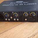 Černý zvukový interface s nápisem Focusrite Saffire 6 USB na horní straně a logem Focusrite vlevo na předním panelu. Přední strana obsahuje dva kombi…