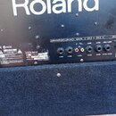 Zadní panel černého komba značky Roland. Na štítku jsou uvedeny údaje MODEL KC-60, SERIAL NO. AT61819 a nápis MADE IN CHINA. Panel obsahuje vstupy a…