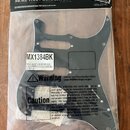 Černý plechový pickguard pro elektrickou kytaru v originálním plastovém balení. Na obalu je nápis Musiclily a slogan MORE THAN GUITAR PARTS. Na bílém…