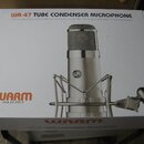 Bílá krabice s produktovou fotografií mikrofonu v šokabsorberu. Na krabici je nápis WA-47 TUBE CONDENSER MICROPHONE a logo WARM AUDIO. Pod názvem mod…