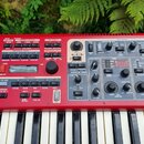 Červený digitální klavír s bílými a černými klávesami. Na ovládacím panelu jsou vidět nápisy PIANO, SYNTH a EXTERN spolu s množstvím tlačítek, posuvn…