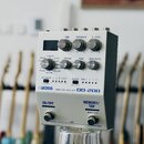 Bílý efekt pedál s nápisy BOSS, DIGITAL DELAY a DD-200. Zařízení má pět ovládacích knoflíků s popisky TIME, FEEDBACK, E. LEVEL, PARAM, TONE a MOD DEP…