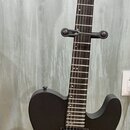 Černá elektrická kytara s matným povrchem, umístěná na stojanu. Na hlavě je viditelné logo LTD a nápis EC-1000. Nástroj má dva humbuckery, jeden ovlá…