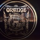 Fotografie zachycuje černý reproduktor s bílým potiskem. V horní části je výrazný nápis ORANGE a pod ním detailní grafický ornament s postavami. Po s…