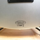 Detail zadní strany stříbrného nástroje s kovickým povrchem. V dolní části je oválný nápis: „Electric guitars & basses made in Indonesia in accordanc…