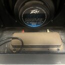 Fotografie zachycuje vnitřek komba s reproduktorem a transformátorem. Na středovém krytu reproduktoru je logo Peavey a nápis BLUE MARVEL, dále text P…