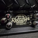 Detailní pohled na přední panel kytarového zesilovače černé barvy. Uprostřed je bílý nápis „DUAL Rectifier ROADSTER™“. Na panelu jsou umístěny chromo…